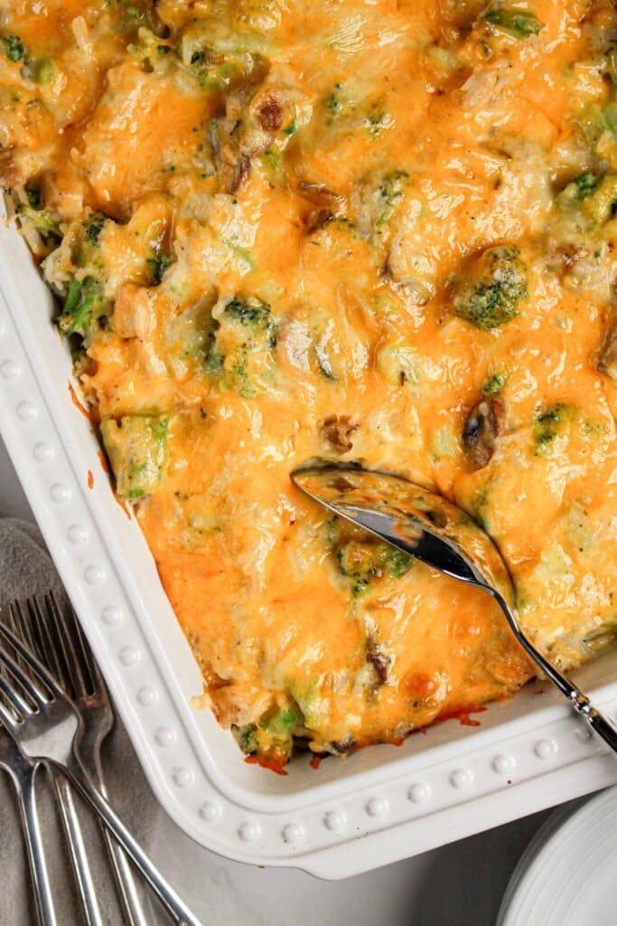 Scoop of chicken broccoli and rice casserole being removed from the baking dish.