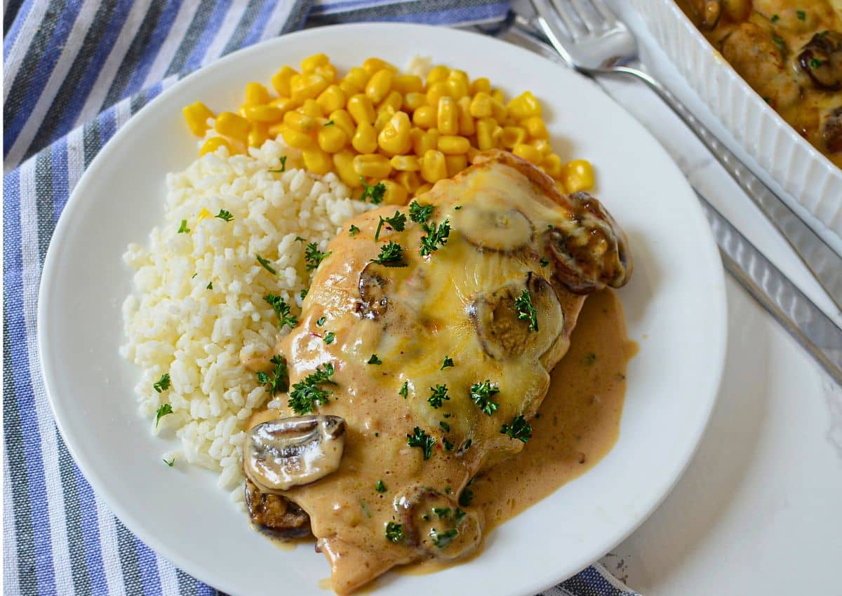 White plate with chicken gloria, white rice, and corn.