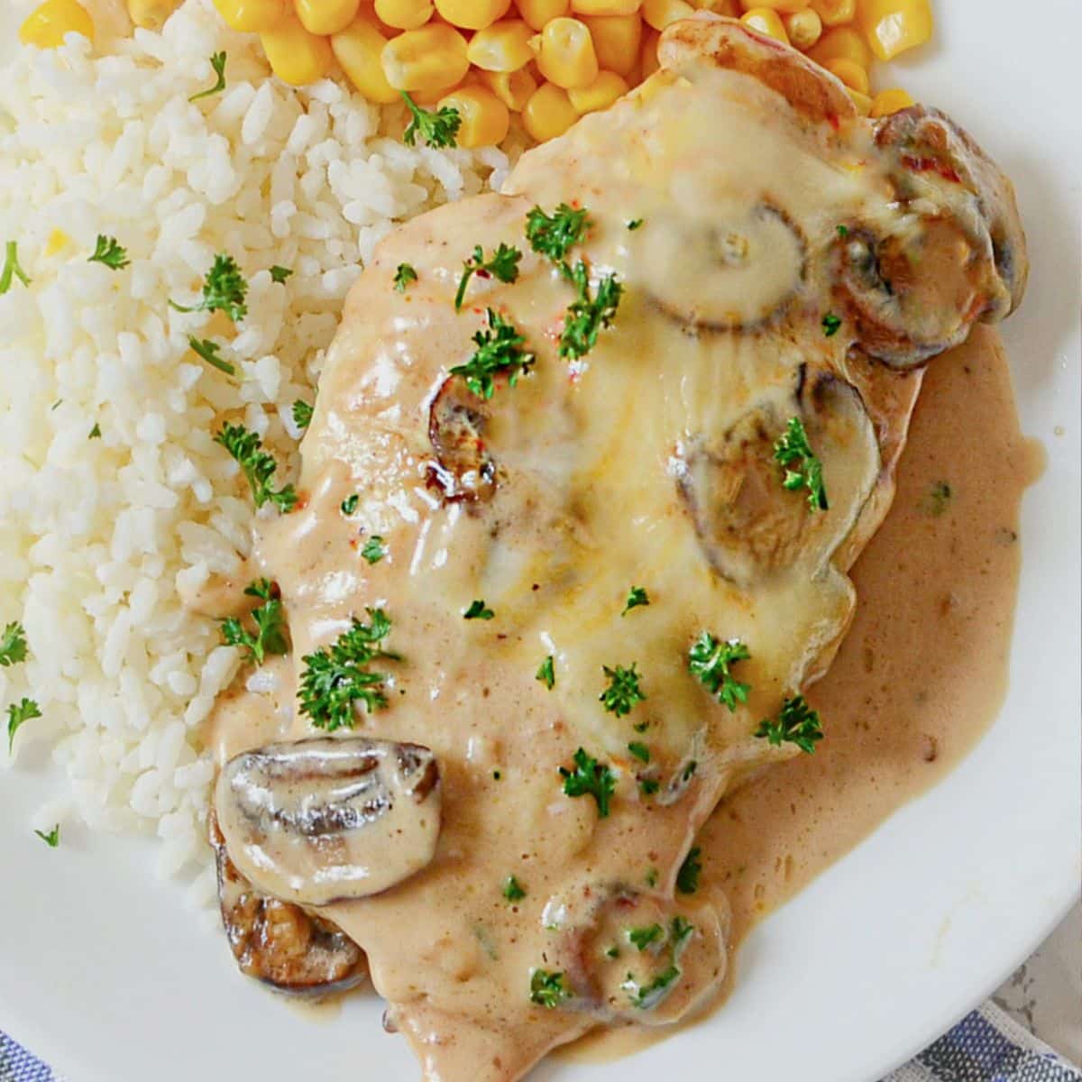 White plate with chicken gloria, white rice, and corn.