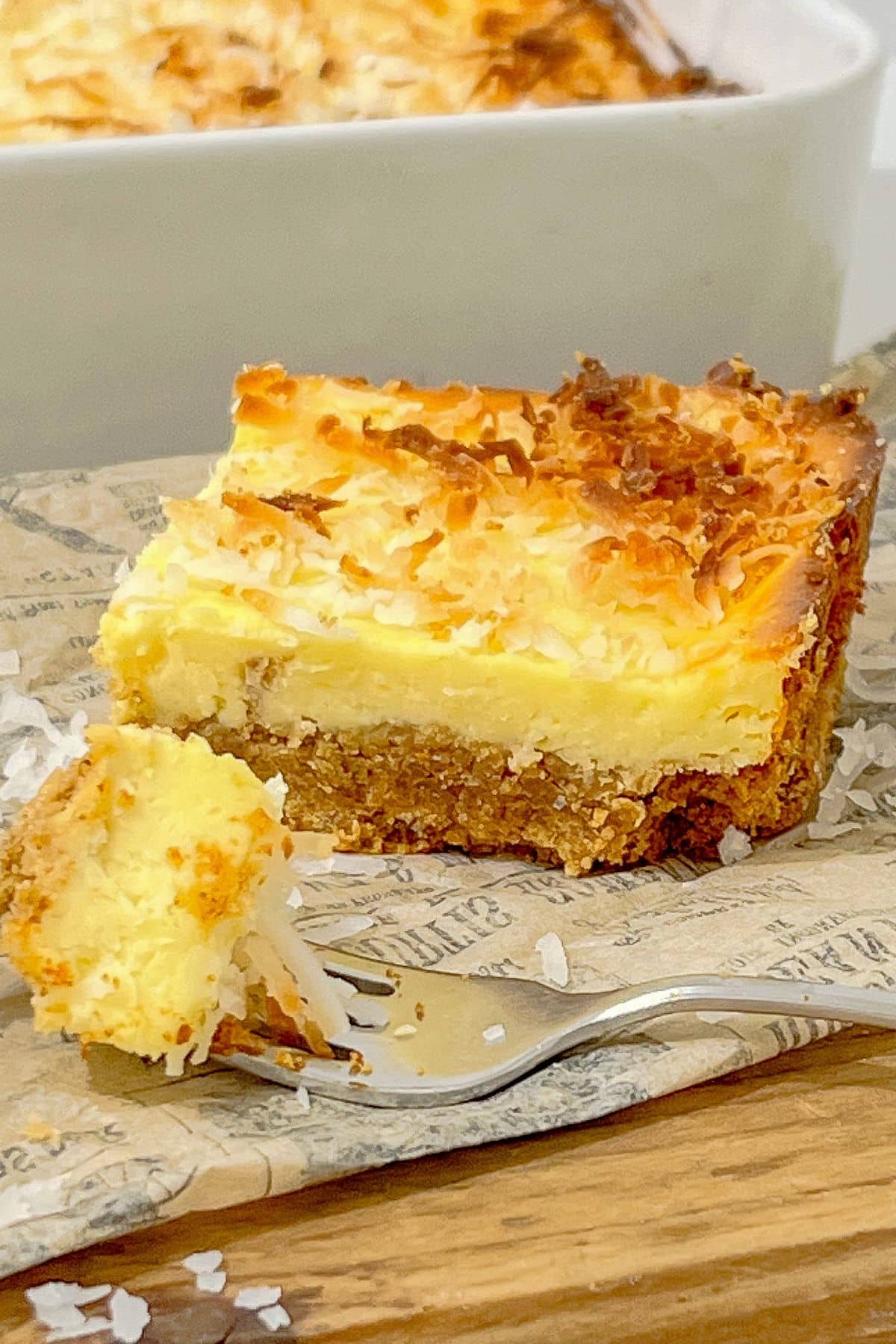 Slice of coconut cream cheesecake bar on a table.