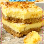 Two slices of coconut cream cheesecake bars stacked on top of each other.