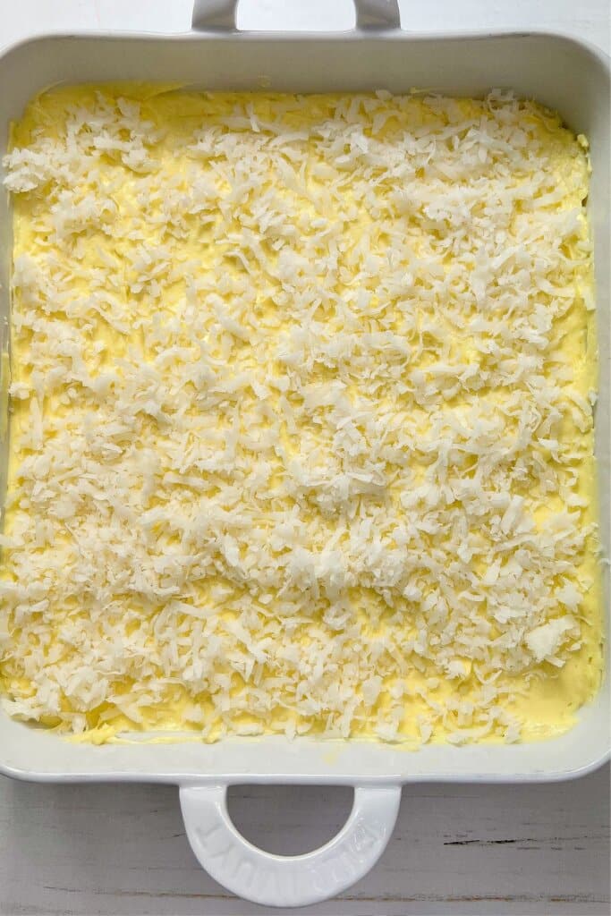 Coconut on top of bars in a baking dish.