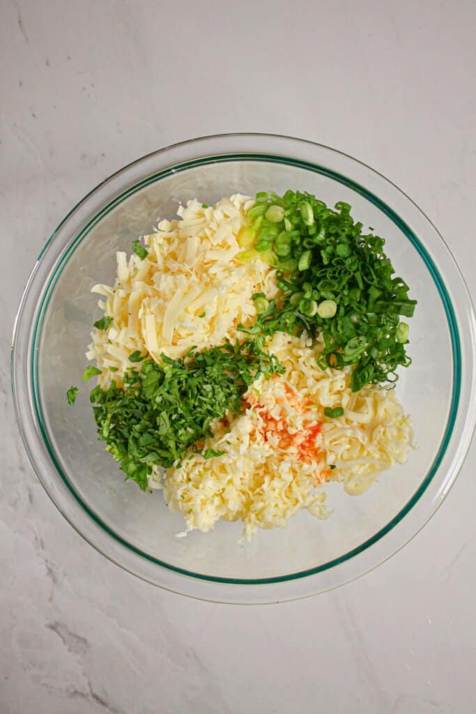 Ingredients being mixed in a glass mixing bowl.