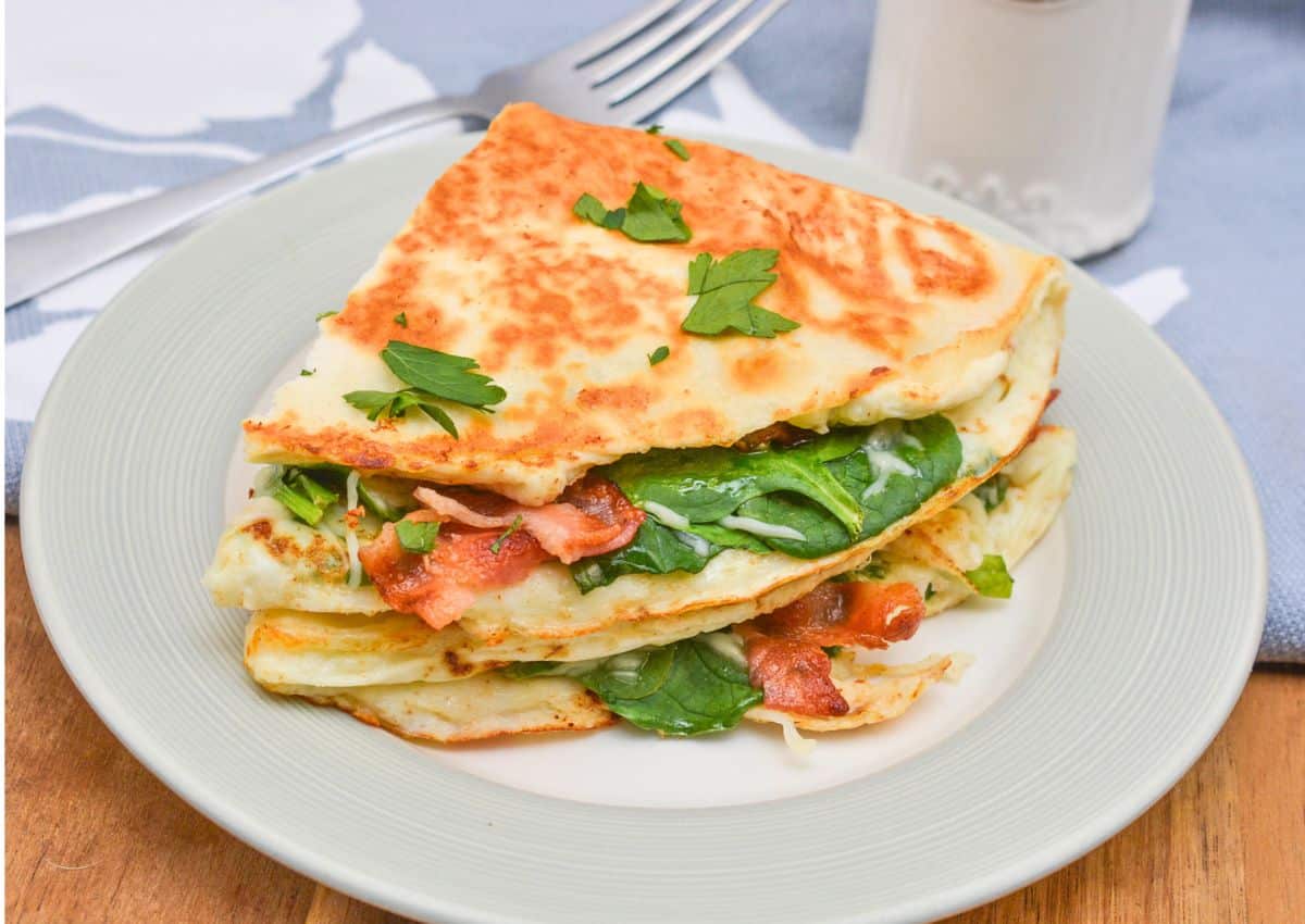 Two quesadillas stacked on a white plate.