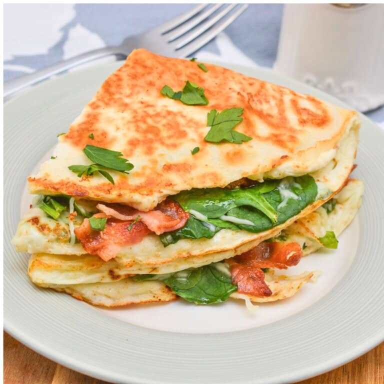 Two quesadillas stacked on a white plate.
