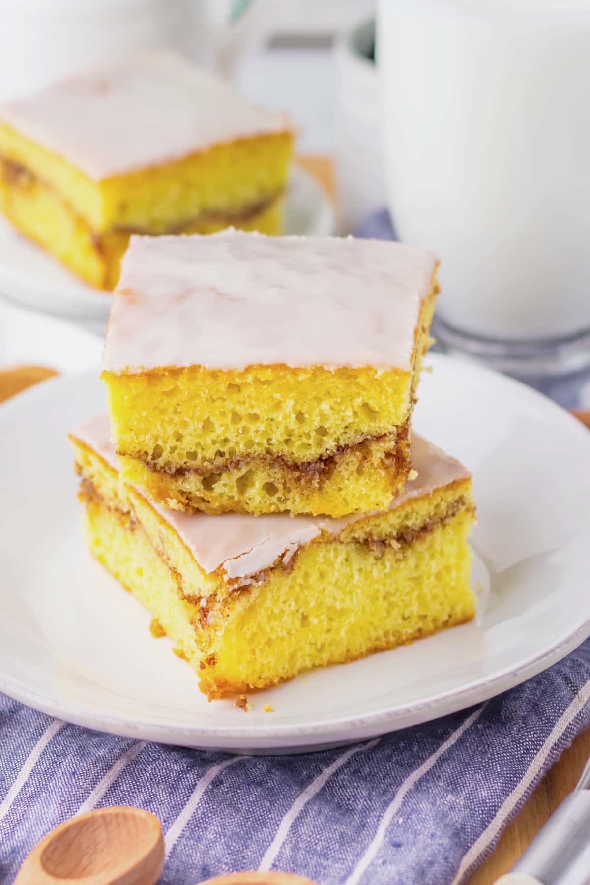 Two slices of honey bun cake stacked on a small white plate.