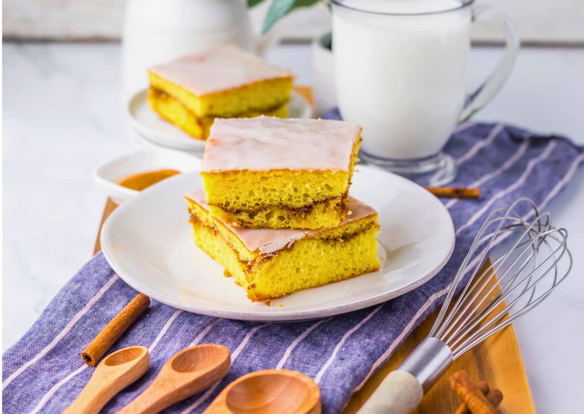 Two slices of honey bun cake stacked on a small white plate.