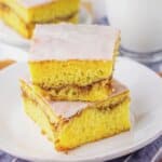 Two slices of honey bun cake stacked on a small white plate.