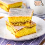 Two slices of honey bun cake stacked on a small white plate.