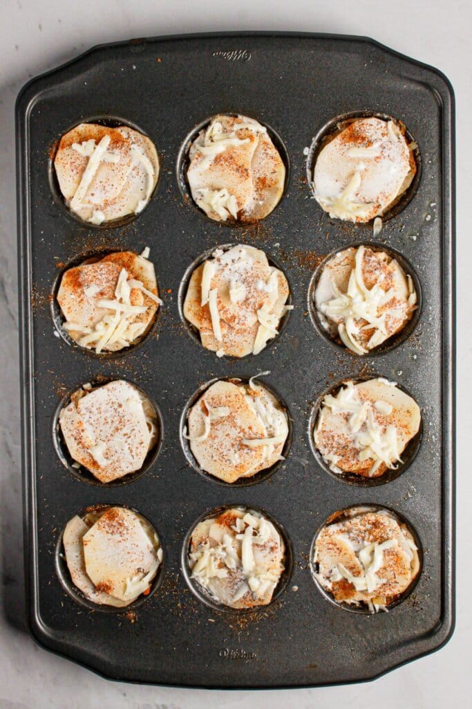 Cupcake pan full of layered spuds.