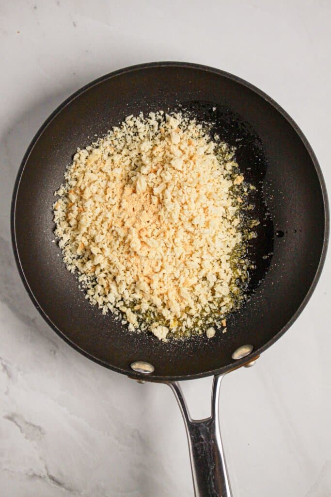 Breadcrumbs being toasted in a skillet.