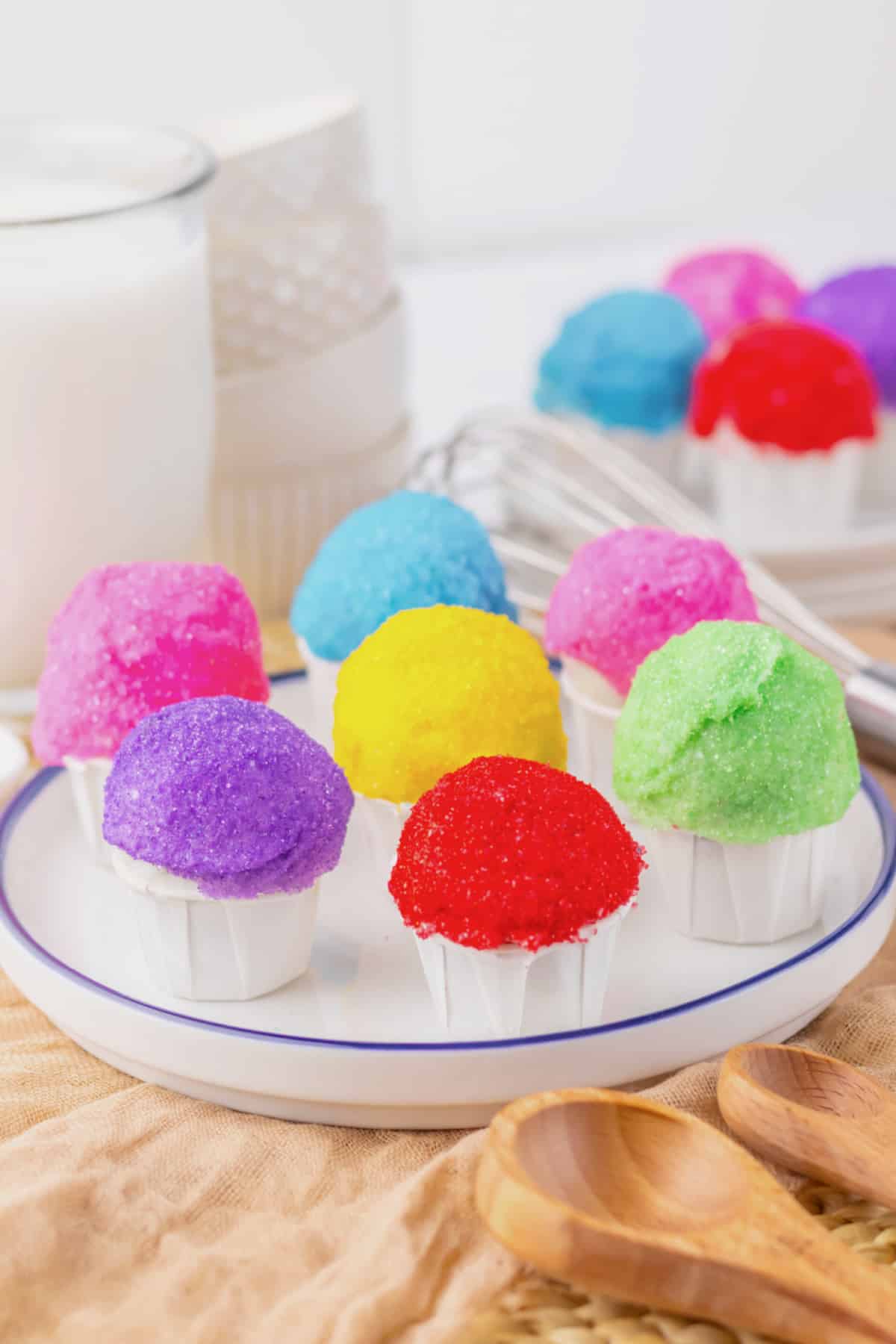Rainbow snowcone oreo truffles on a white plate.