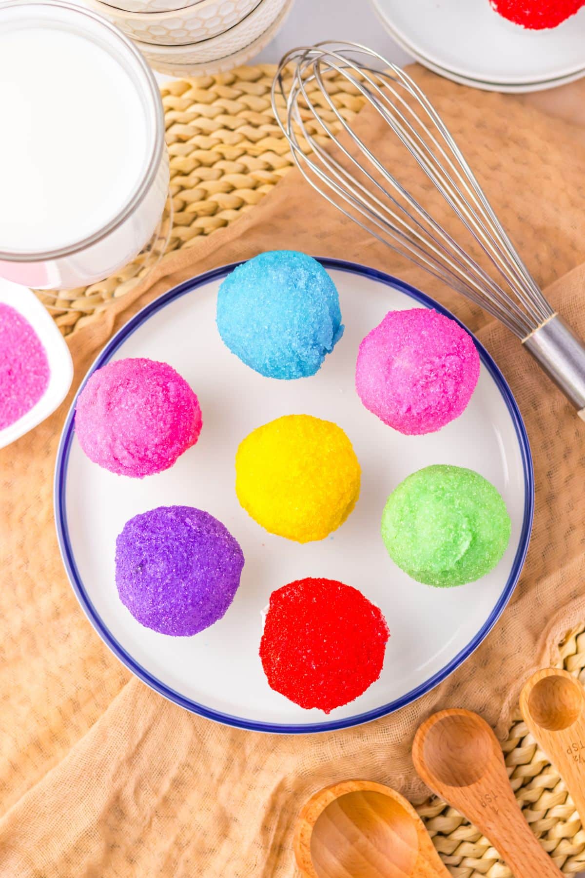 Rainbow snowcone oreo truffles on a white plate.