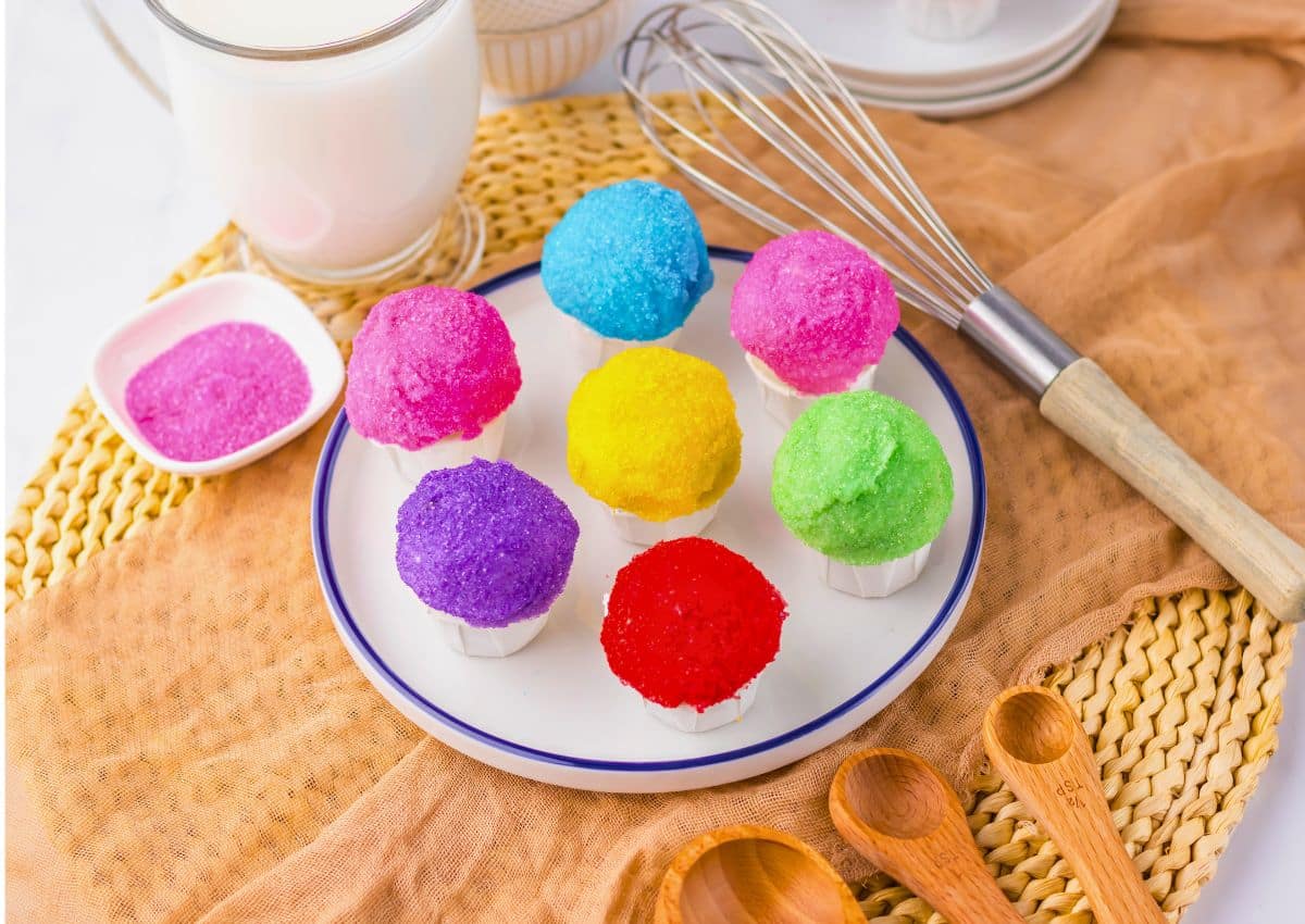 Rainbow snowcone oreo truffles on a white plate.