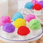Rainbow snowcone oreo truffles on a white plate.