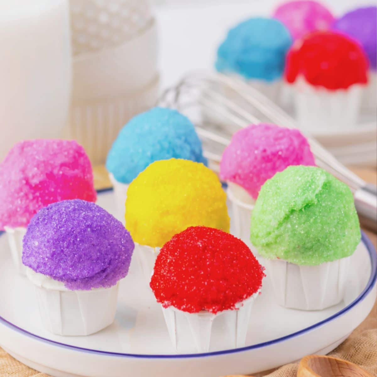 Rainbow snowcone oreo truffles on a white plate.