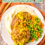 Salisbury steak on a plate with peas and carrots.
