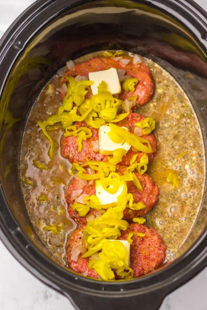 Peppers being placed on top of meat.