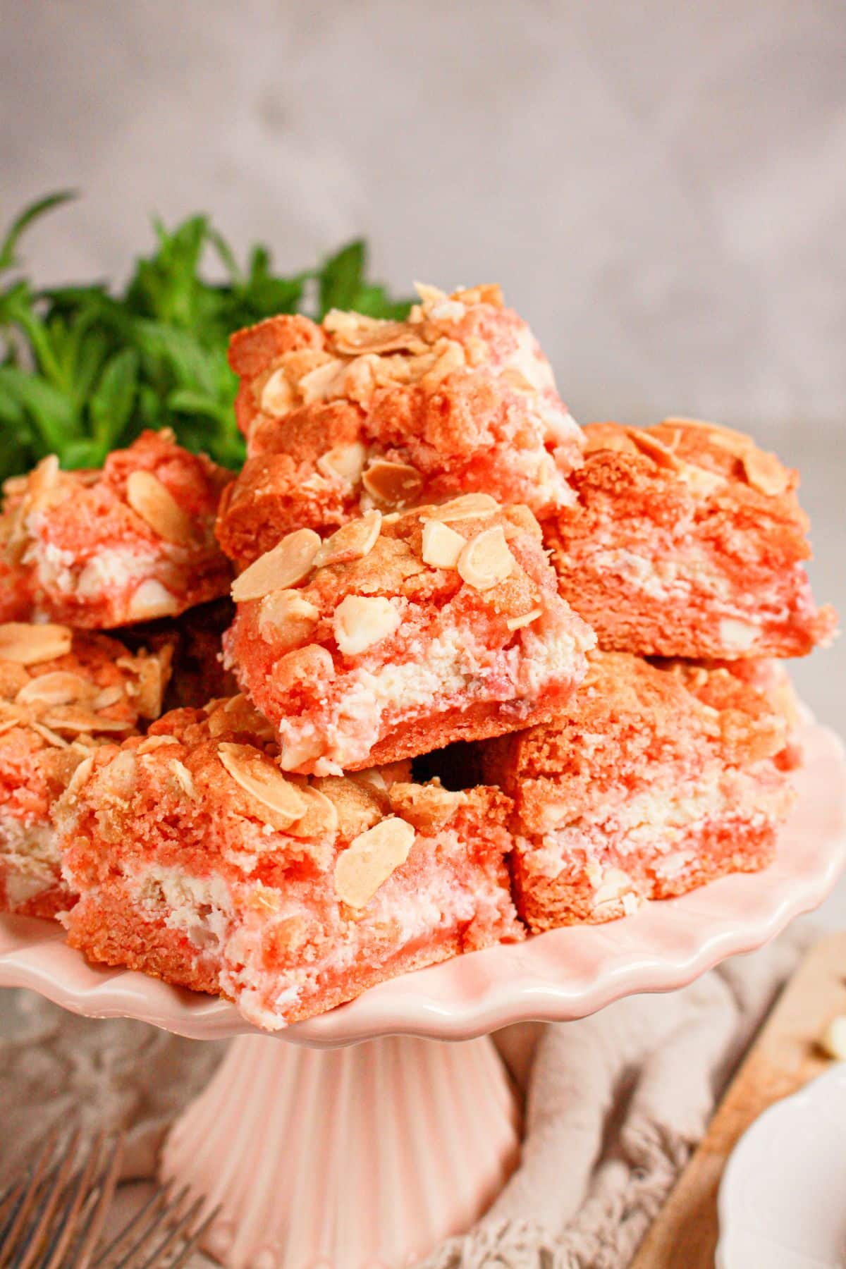 Strawberry brownies stacked on a white plate.