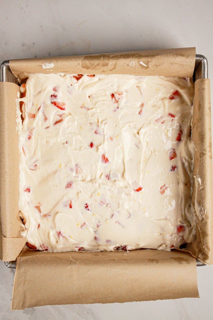 Cream cheese mixture being spread on top of dessert.