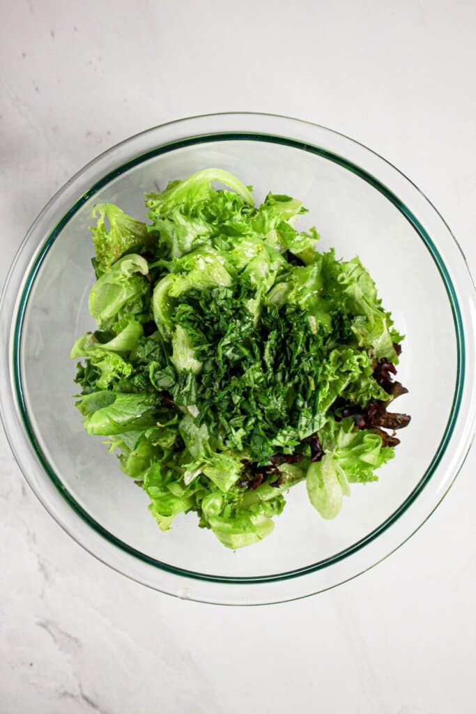 Greens in a glass mixing bowl.