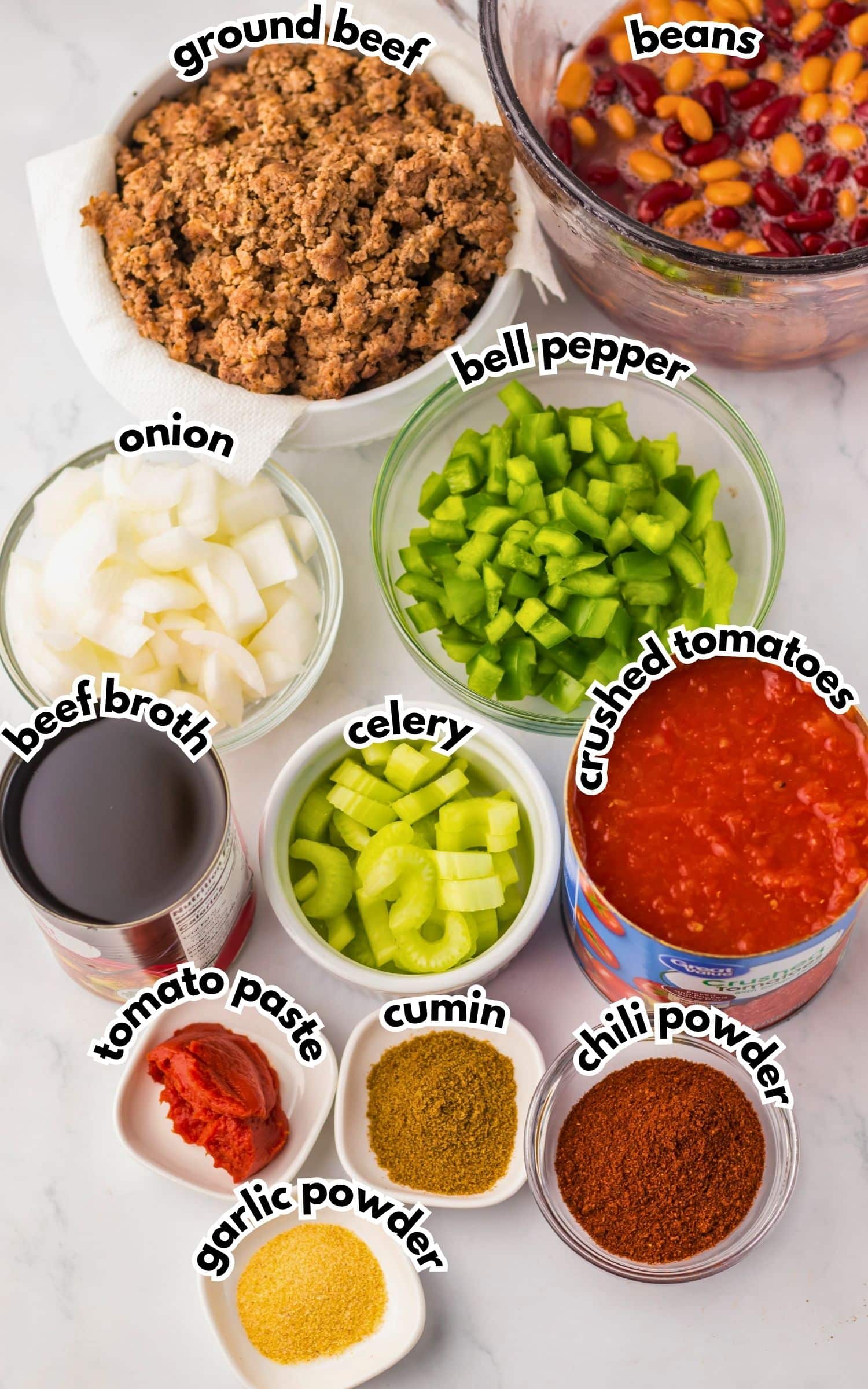 Bowls of ingredients labelled with text on a counter.