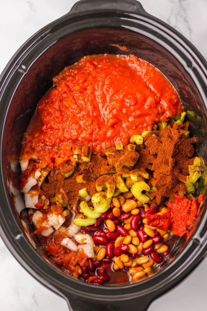 Ingredients added to a black crock pot.