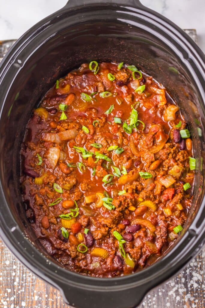 Cooked soup in a black crock pot.
