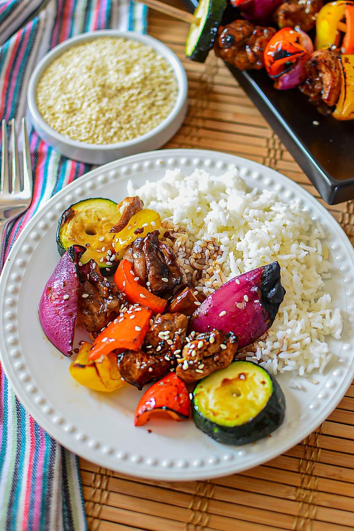 Plate with asian chicken kabobs and rice.