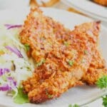 Two bbq chicken tenders on a plate.