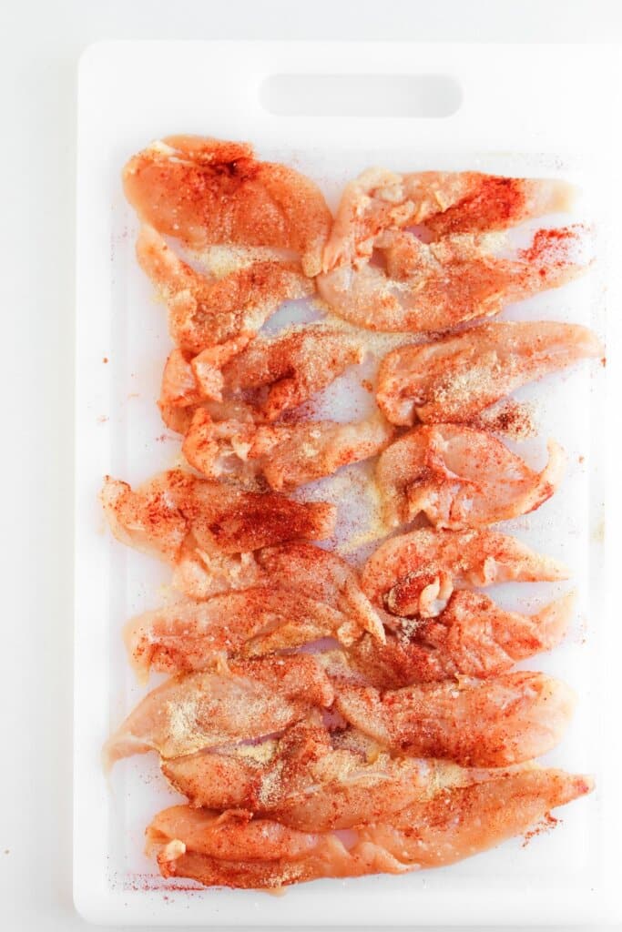 Pieces of meat being seasoned on both sides.
