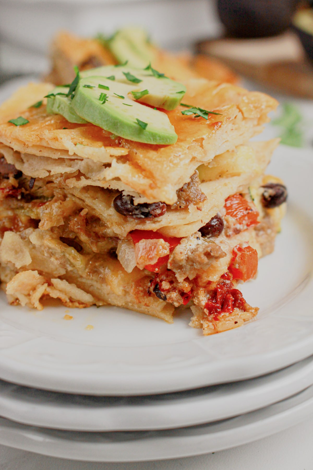 Slice of ground beef enchilada casserole on a small plate.