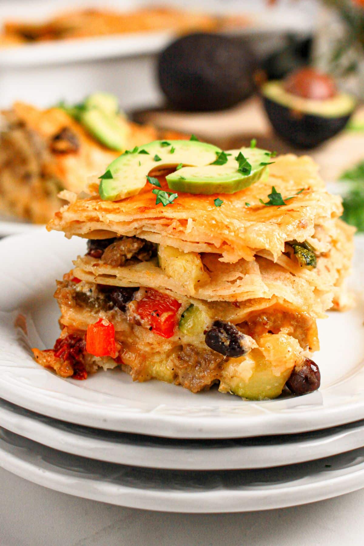 Slice of ground beef enchilada casserole on a small plate.