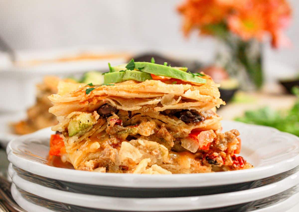 Slice of ground beef enchilada casserole on a small plate.