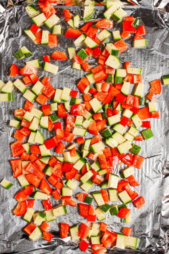 Red pepper and zucchini on a baking sheet.