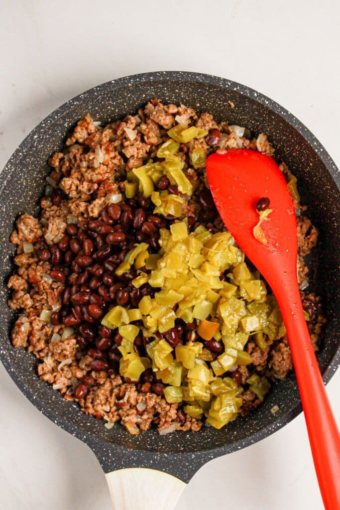 Meat, beans, and peppers in a skillet.