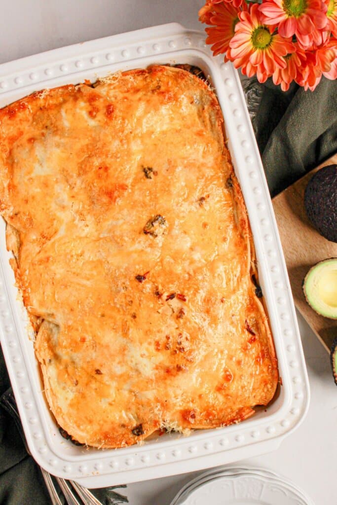 Finished beef enchilada casserole in a white baking dish.