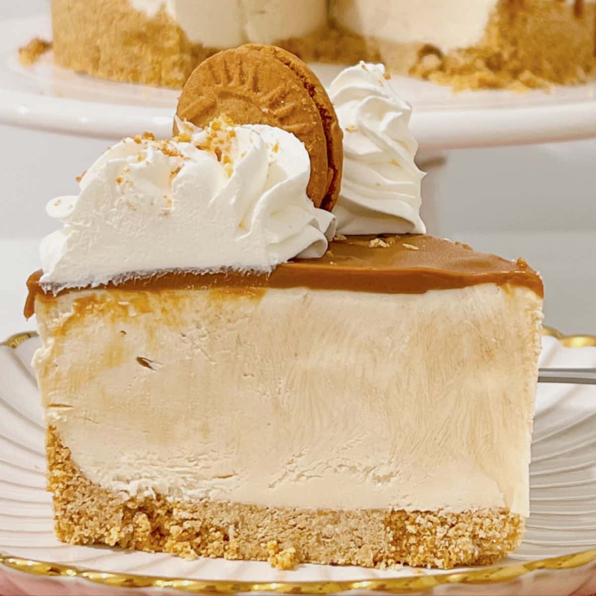 Slice of biscoff cheesecake on a scalloped plate.