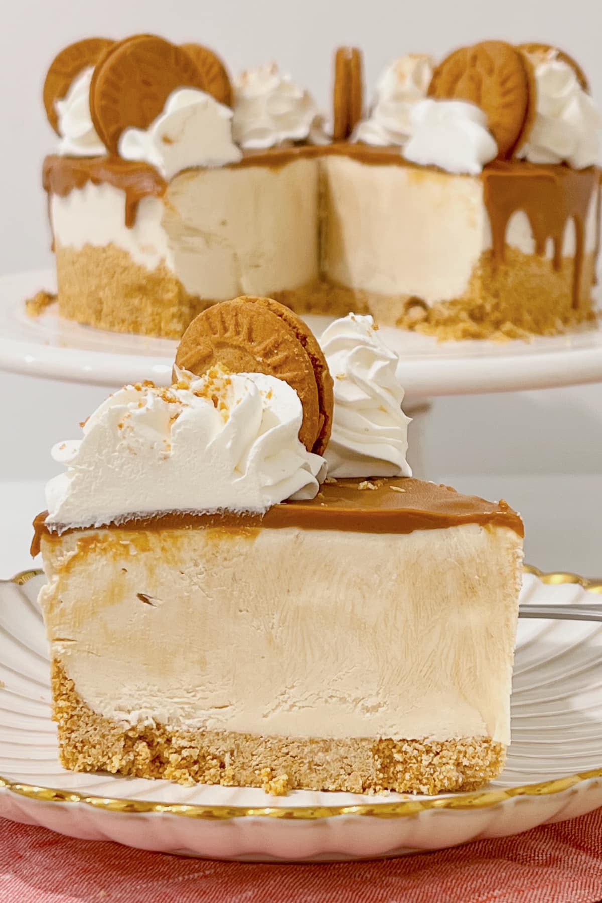 Slice of biscoff cheesecake on a scalloped plate.