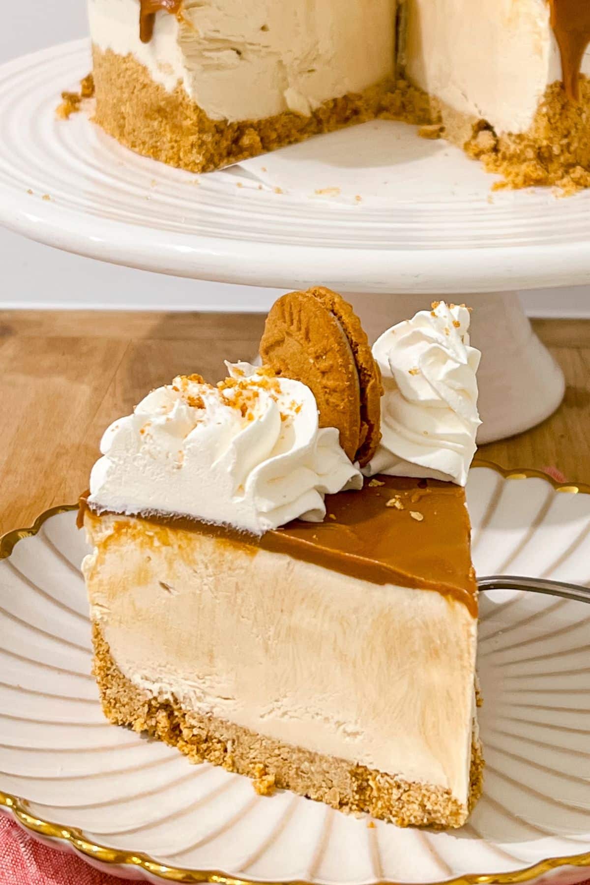 Slice of biscoff cheesecake on a scalloped plate.