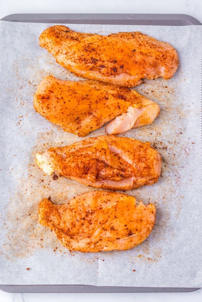 Seasoned meat on a baking sheet.