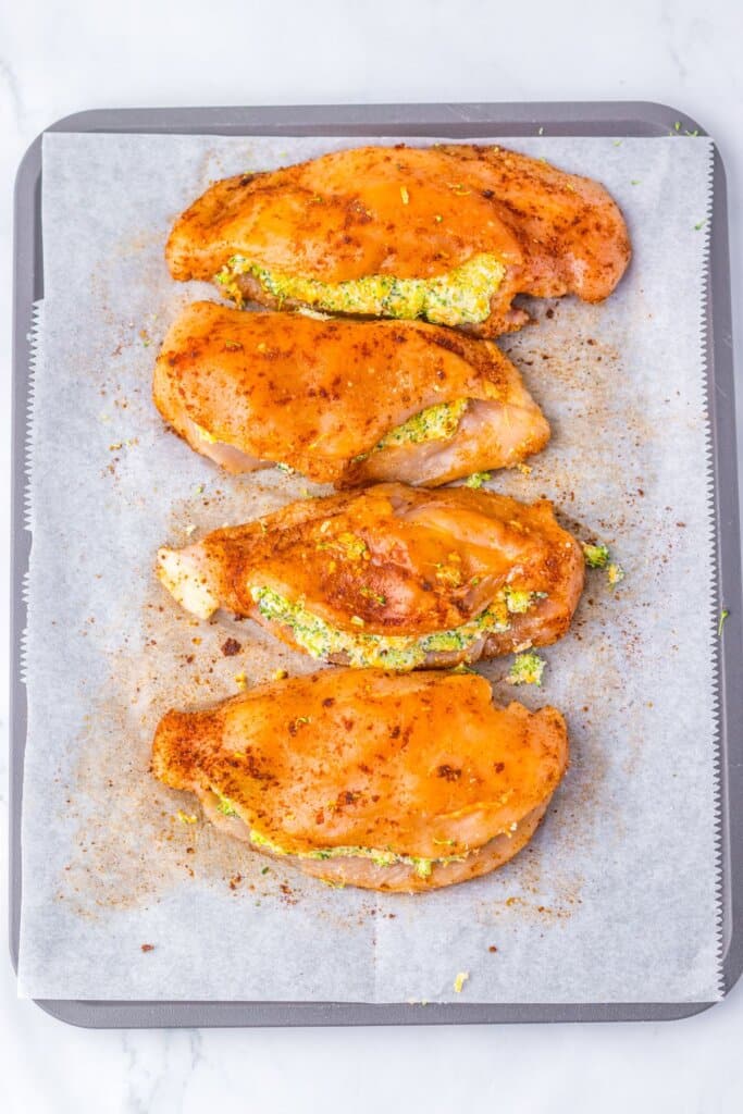 Meat being filled on a baking sheet.