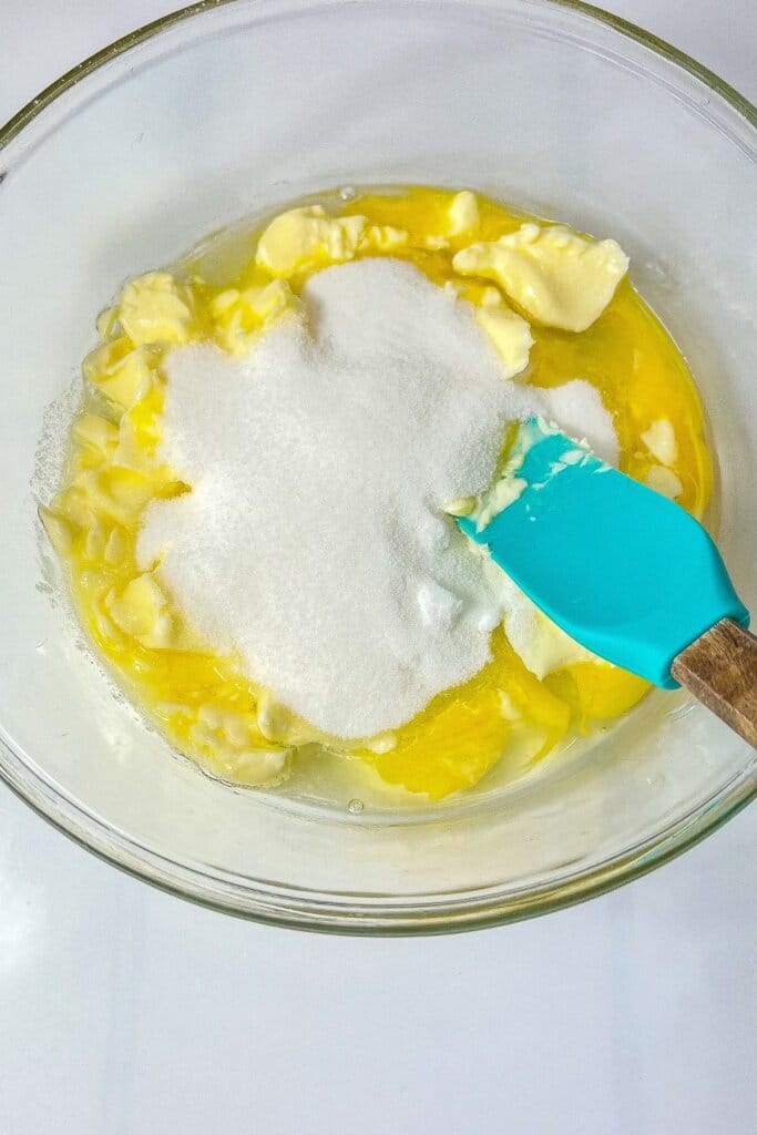 Butter and sugar in a glass mixing bowl.