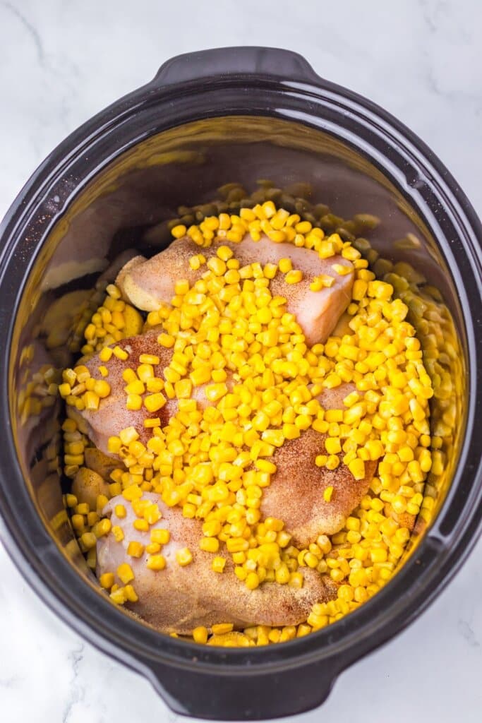 Corn and chicken breasts in a crockpot.