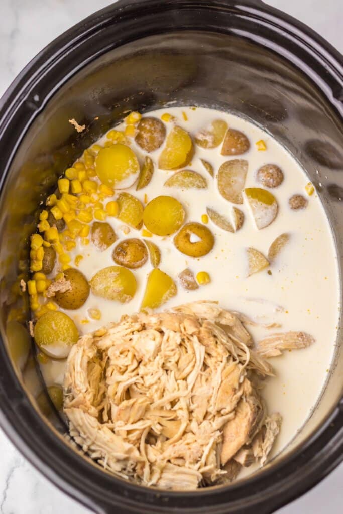 Chicken and cream being added to a crockpot.