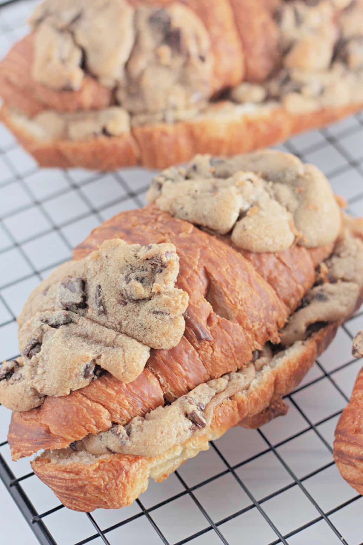 Chocolate chip cookie croissants on a wire cooling rack.