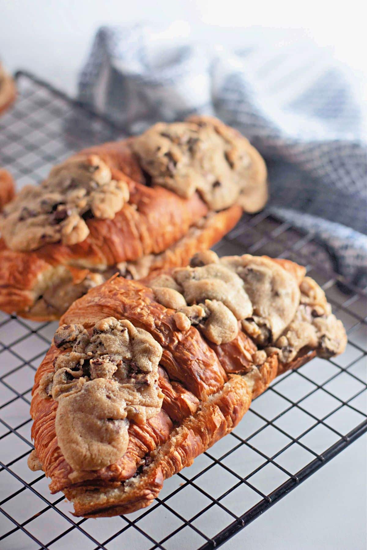 Chocolate chip cookie croissants on a wire cooling rack.