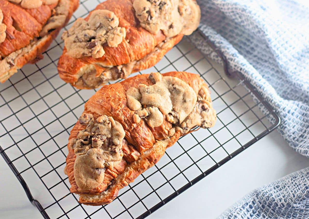 Chocolate chip cookie croissants on a wire cooling rack.