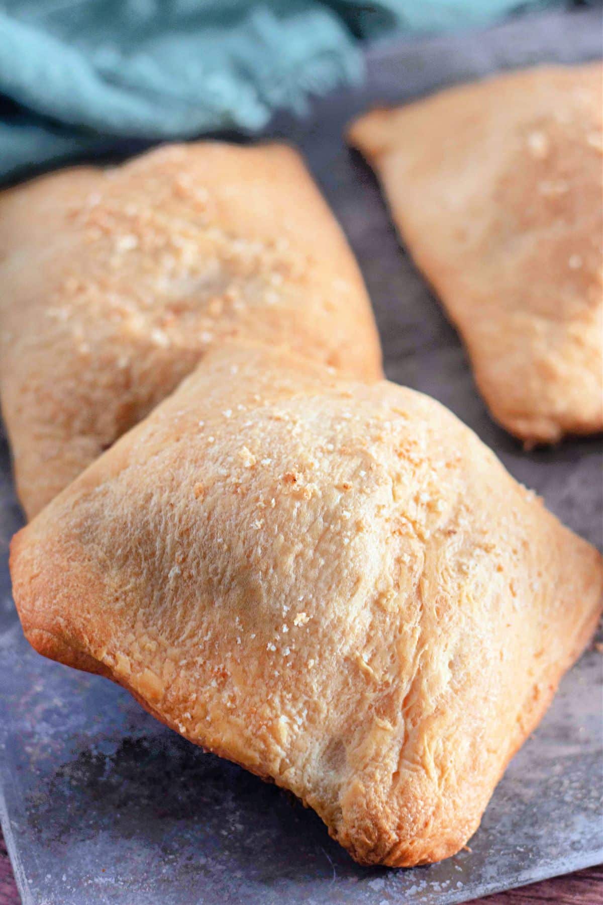 Crescent roll chicken pockets on a cutting board.