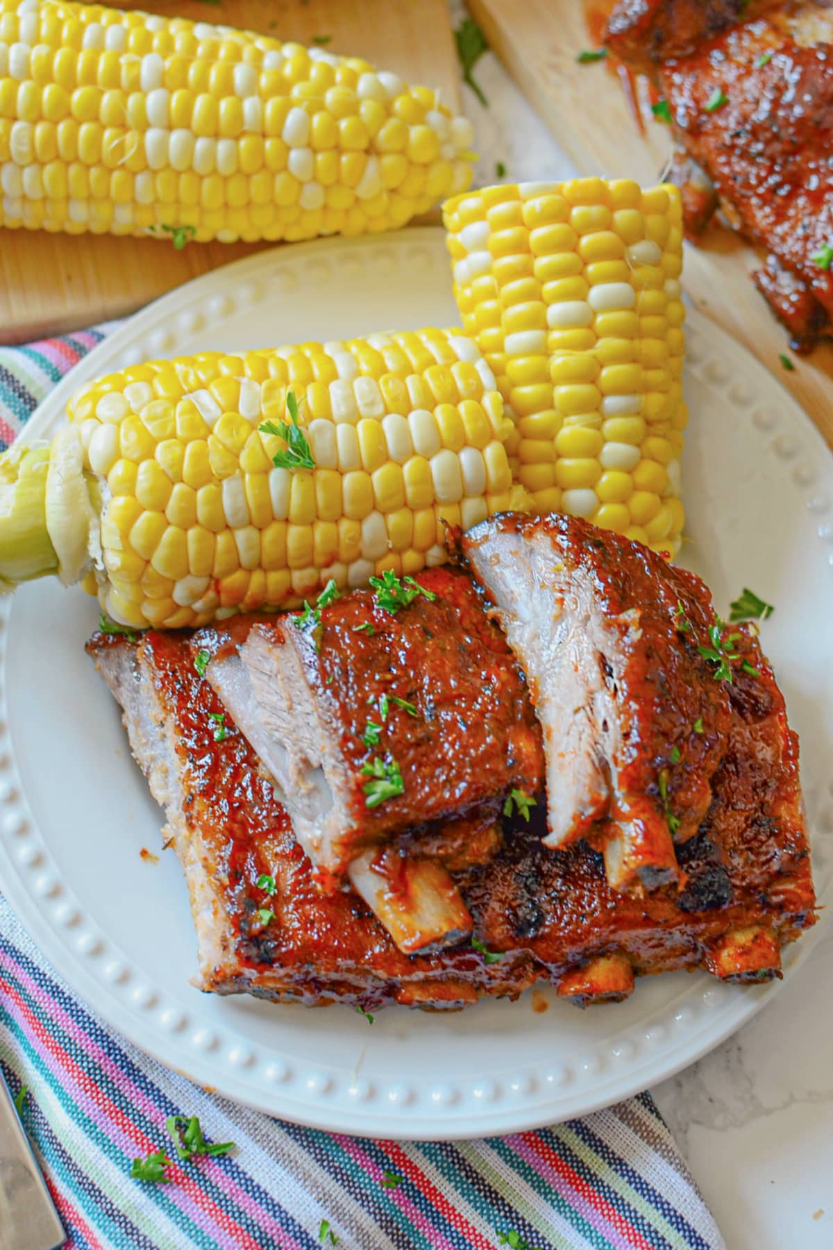 Ribs on a plate with corn on the cob.